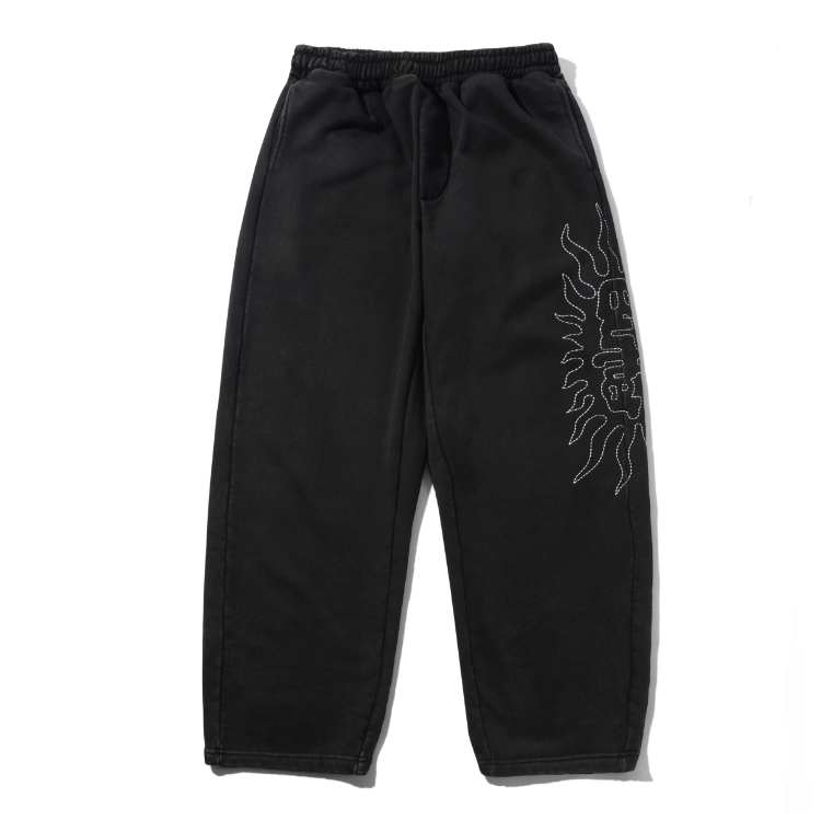 Black sweatpants with a white flame graphic and 'BREATHE' text on the left leg, displayed next to a light gray version of the same pants on a white background.