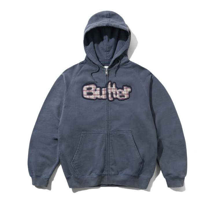 A slate blue zip-up hoodie with a front kangaroo pocket and a distressed 'Butter' logo across the chest, displayed on a clean white background.
